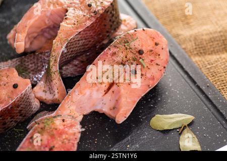 Pezzi crudi di pesce rosso con condimenti. Foto Stock