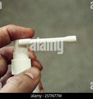Persona con inalatore spray in mano Foto Stock