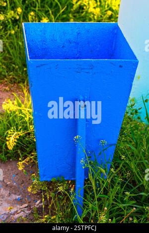 Cestino vuoto dipinto di colore blu brillante nel giardino Foto Stock