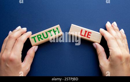 Simbolo della verità o della menzogna. Parola concettuale verità o menzogna su blocchi di legno. Mano d'affari. Splendido sfondo blu intenso. Business and Truth or Lie Concept. Foto Stock