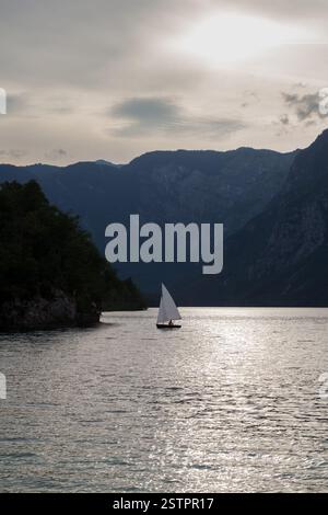 Vista panoramica di una barca a vela su un lago nebbioso, Bohinj. Slovenia Foto Stock