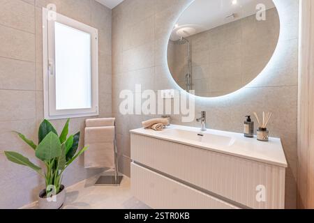 un'immagine di un bagno con piastrelle in pietra e specchio illuminato nella casa vacanze mediterranea Foto Stock