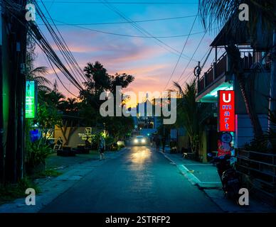 Piccola strada in Seminyak al tramonto, in Bali, Indonesia Foto Stock