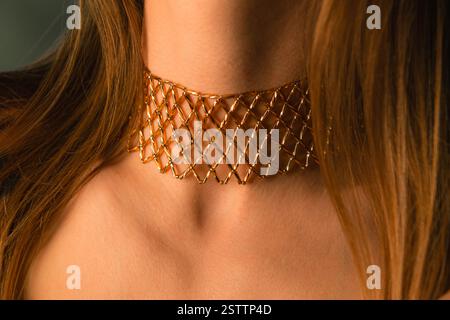 Collana decorata dorata realizzata con perline su un collo di modello non identificato, gioielli etnici Foto Stock