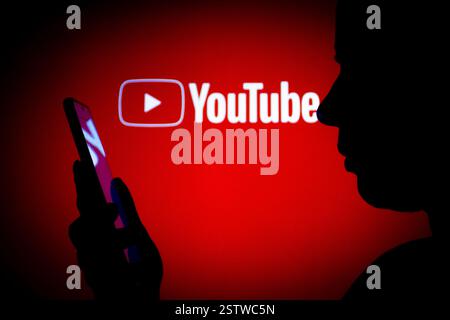 14 marzo 2022, Brasile. In questa immagine, il logo di YouTube visto sullo sfondo di una donna silhouette che tiene in mano un mobil Foto Stock