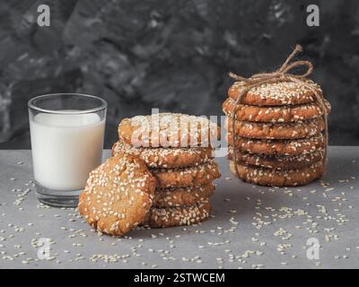 Biscotti Vegan Tahini fatti in casa in pila con un bicchiere di latte Foto Stock