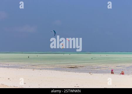 Kite surf sulla spiaggia tropicale, bassa marea. Kite surfisti sul mare. Vista panoramica dell'Oceano Indiano con kite board, Zanzibar, spiaggia di Paje. Concetto di persone attive Foto Stock