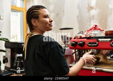 Una giovane donna con i capelli intrecciati prepara il caffè in un invitante caffè, irradiando calore e fascino. Foto Stock