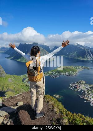 Joyful Hiker abbraccia la splendida vista sui maestosi fiordi norvegesi, Lofoten Foto Stock