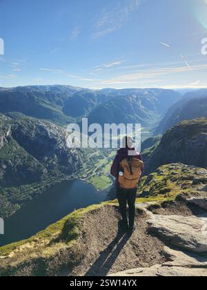 Vista maestosa sul fiordo norvegese all'alba con escursionismo sul Rock Edge Foto Stock
