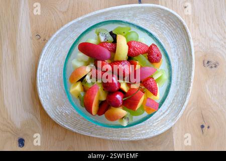 Una vivace Macedonia di frutta con fragole, pesche, kiwi e ciliegie Foto Stock