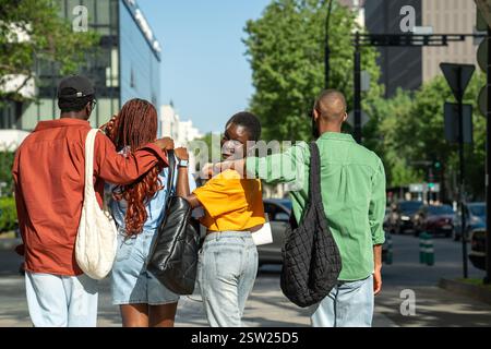 Amici afroamericani felici studenti che abbracciano passeggiando per strada passeggiano per la città dopo le lezioni Foto Stock