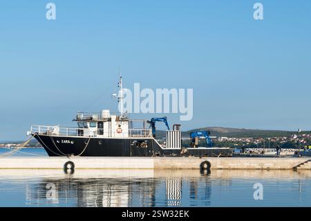 Biograd, Croazia - 10 ottobre 2020: Peschereccio, peschereccio ormeggiato sul molo con riflessi in mare Foto Stock