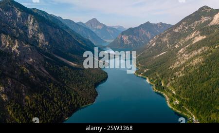 Vista aerea mozzafiato del tranquillo lago Plansee circondato dalle maestose montagne dell'Austria Foto Stock