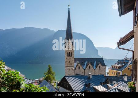 Una mattinata serena a Hallstatt, Austria, con montagne e torreggiante vicino al lago tranquillo Foto Stock
