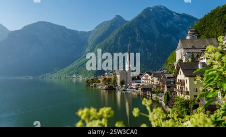 Splendida vista su Hallstatt con montagne e un lago tranquillo che riflette la luce del mattino Foto Stock