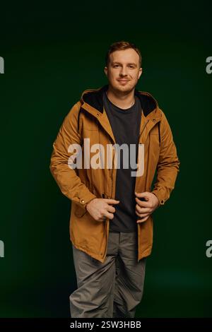 Un uomo elegante e casual si pone con sicurezza su uno sfondo suggestivo. Foto Stock