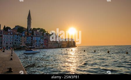 Tramonto dorato sul pittoresco lungomare di Rovigno ed edifici colorati lungo il Mare Adriatico Foto Stock
