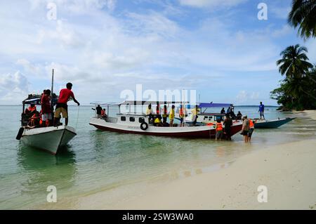 Isola di Karimunjawa, reggenza di Jepara, Giava centrale, Indonesia - 11 giugno 2017: Piccola barca tradizionale di trasporto ormeggiata sulla spiaggia con persone Foto Stock