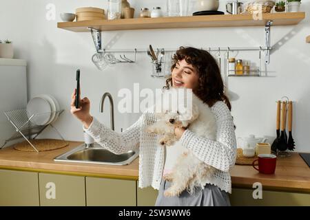 Una giovane donna sorprende mentre si fa un selfie con il suo cane soffice in una cucina accogliente. Foto Stock