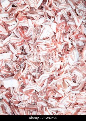 Un primo piano di pancia di maiale affettata al momento, disposta in un vassoio di metallo, pronta per la vendita in un mercato. Il grasso marmorizzato e la carne magra creano una consistenza ricca, mak Foto Stock