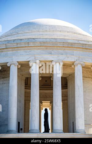 WASHINGTON DC - la sagoma della statua di Thomas Jefferson è visibile attraverso le colonne del Jefferson Memorial alla luce del mattino. La statua di bronzo di 19 piedi, creata dallo scultore Rudulph Evans, rimane in ombra all'interno della rotonda, mentre la luce del sole illumina le colonne di marmo esterne del monumento. Il profilo laterale crea un drammatico contrasto tra luce e ombra in questa vista del monumento neoclassico. Foto Stock
