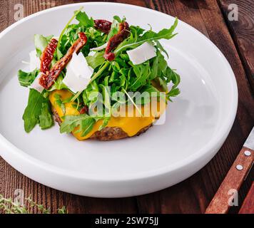 Cheeseburger gourmet con rucola e pomodori secchi Foto Stock