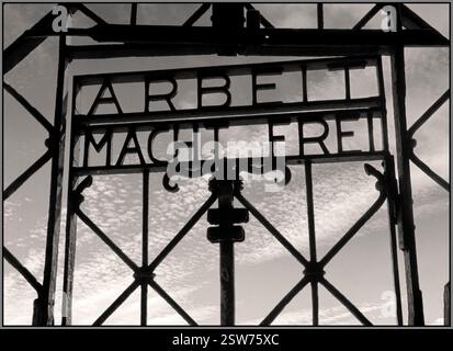 Porta d'ingresso DI DACHAU al campo di concentramento nazista di DACHAU, con la famigerata frase "Arbeit macht frei" ("il lavoro ti libera"). Dachau fu il primo campo di concentramento nazista, fondato nel 1933 vicino a Monaco di Baviera, in Germania. Servì come modello per altri campi di concentramento e un centro di formazione per il personale delle SS. Lo slogan "Arbeit macht frei" è stato utilizzato all'ingresso di diversi campi di concentramento nazisti. Era destinato a ingannare i prigionieri e mascherare il vero scopo del campo, il lavoro forzato e lo sterminio. Dachau fu liberata dalle forze americane il 29 aprile 1945. Foto Stock