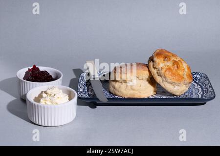 Focaccine inglesi tradizionali fatte in casa. Gli scones sono serviti con marmellata e crema coagulata. Un delizioso tè inglese alla panna. Foto Stock