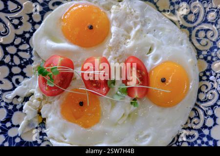 Le uova e i pomodori ciliegini sono il lato soleggiato della colazione Foto Stock