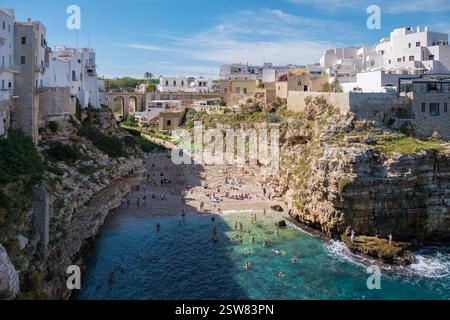 Polignano a Mare la splendida bellezza della Puglia insenatura nascosta con bagnanti e coste rocciose Foto Stock