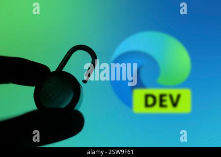 Dacca, Bangladesh - 2 novembre 2024: Una mano tiene un lucchetto sbloccato davanti al logo Microsoft Edge Dev Foto Stock