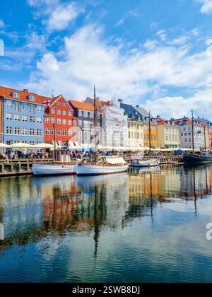 I colorati edifici sul lungomare si riflettono splendidamente nelle calme acque del porto di Copenaghen Foto Stock