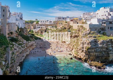 Polignano a Mare la splendida bellezza della Puglia insenatura nascosta con bagnanti e coste rocciose Foto Stock