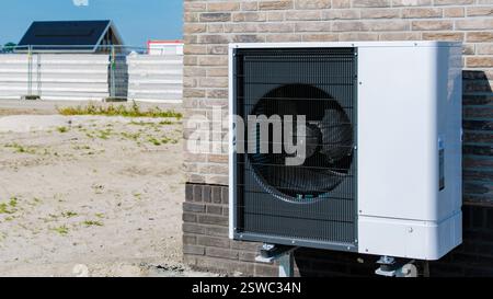 Moderna pompa di calore della sorgente d'aria installata da New Home Construction durante il chiaro Sunny Day Foto Stock