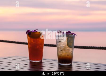 Goditi un drink tropicale al tramonto sull'isola di Koh Munnork in Thailandia Foto Stock