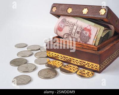 Dirham di soldi arabi nella vecchia scatola di legno. Foto Stock