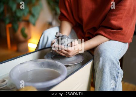 Ceramista femmina che forma pareti di vaso su ruota di ceramica rotante, formando argilla in forma Foto Stock