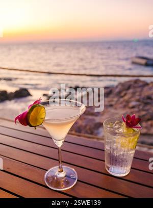 Gustate cocktail tropicali al tramonto sull'isola di Koh Munnork a Rayong, Thailandia Foto Stock