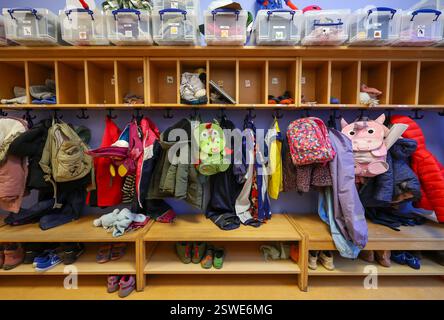 20.12.2024, Germania, , - immagine simbolica KITA. Cappotti, giacche e zaini di unicorno di bambini appesi a una scacchiera in un asilo. 00X241220D0 Foto Stock