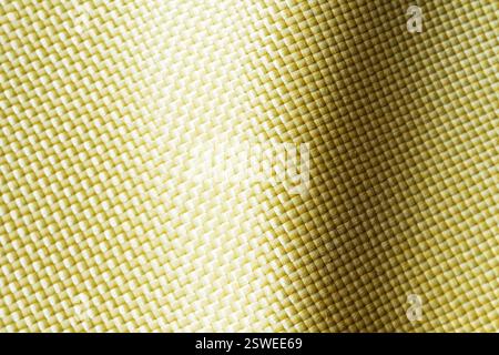 Materiale antiproiettile aramide. Sfondo kevlar aramide. Trama e motivo kevlar dorati. Foto Stock