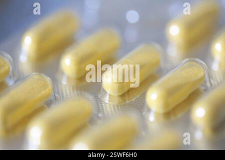 Integratore alimentare, capsule vitaminiche gialle in blister Foto Stock