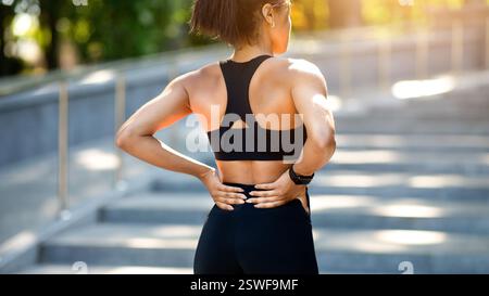 Donna nera che ha dolore alla schiena più basso, è stata ferita durante l'esercizio fisico Foto Stock