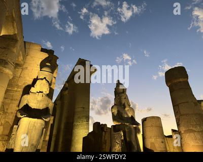 Colosso di Ramesse II seduto al Tempio di Luxor durante il tramonto, Egitto Foto Stock