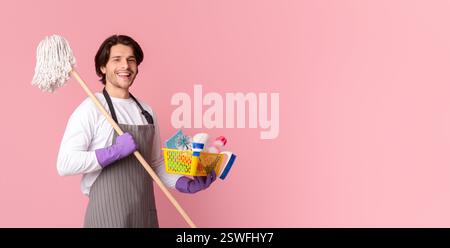 Ritratto di Happy Man che tiene Mop e secchio con gli attrezzi di pulizia Foto Stock
