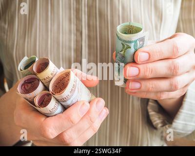 Dirham arabi. Banconote arricciate nelle sue mani. Foto Stock
