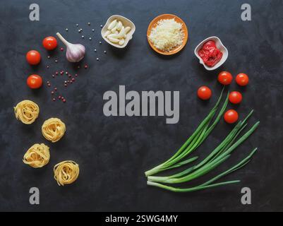 Ingredienti per spaghetti su sfondo nero. Copiare lo spazio per il testo. Foto Stock