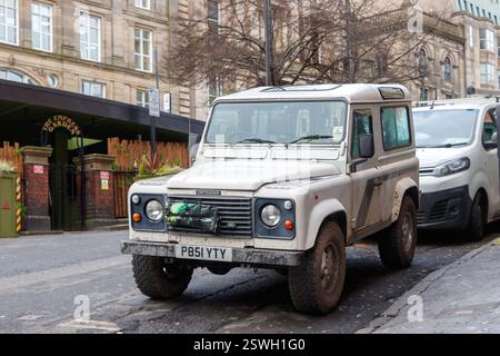 Un'aspra Land Rover Defender color crema bianca degli anni '1990 parcheggiata in una strada urbana con edifici storici a newcastle upon tyne nel regno unito Foto Stock