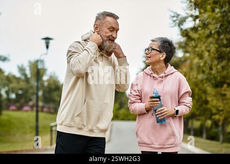 Una coppia amorevole ride insieme in un parco tranquillo, godendosi il tempo trascorso insieme. Foto Stock
