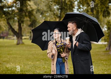 Una coppia amorevole condivide le risate mentre cammina insieme in un parco vivace, godendosi la natura. Foto Stock